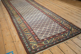 Angled view of a vintage Persian runner's platinum ground with a detailed serrated leaf border.