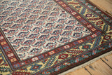 Angled detail of a vintage Persian runner's even wear, showing the shrub-patterned field and goldish leaf border.
