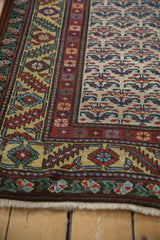 Intricate serrated leaf border on a gold ground, detailing the corner of a vintage Persian runner.