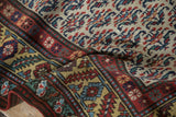 Intricate hand-knotted detail on a Persian rug's serrated leaf border and platinum field.