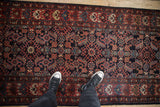 View from above showing the geometric Herati motif in navy and brick red on a Hamadan runner.