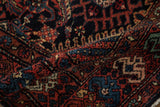 Close-up of a vintage Hamadan rug's even pile and Herati design in navy, red, and dusty teal.