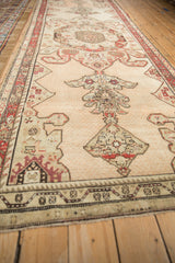 Low-angle view of a distressed antique Karabagh runner highlighting its length and medallion design.