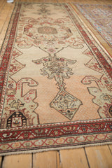 Angled view of an antique Karabagh runner showing its full length and dynamic color abrashes.