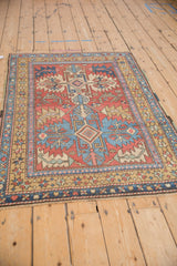 Full angled view of a vintage Heriz rug's geometric medallion and starburst border.