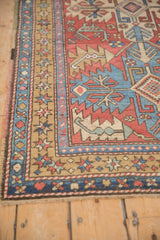 The intricate starburst blossom border and short pile of a vintage Persian Heriz rug.