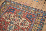 Intricate starburst blossom border and hand-knotted pile on a vintage Heriz rug corner.