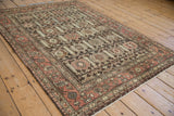Vintage distressed Hamadan rug showing unique boteh border and charcoal field blossoms.