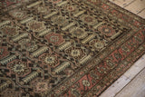 Distressed vintage Hamadan rug corner, with madder red boteh border and earthy patterned field.
