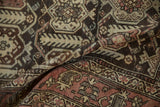 Distressed vintage Hamadan rug detail, showing time-softened madder red, charcoal, and ivory motifs.