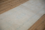 Distressed vintage Karaja rug texture with faded powder blue and ivory motifs.