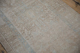 Textured pile of vintage distressed Karaja runner showing faded beige, brown, and blue patterns.
