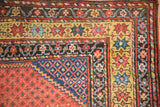 Antique Northwest Persian rug corner, saffron yellow starburst and blue vine borders, red field.