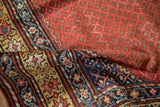 Folded antique Northwest Persian runner showing ruby field with blue botehs, gold and sapphire borders.