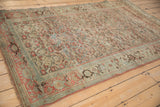 Side angle of a distressed Bijar rug showing the allover Herati pattern with time-softened colors.