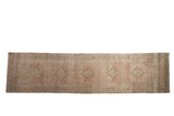 Distressed Persian Serab runner with a row of geometric medallions in dusty blush, beige, and jade green.