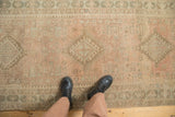 A person's view looking down at the distressed Serab runner's faded geometric pattern and low-pile texture.