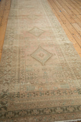 A long perspective on a distressed Serab runner reveals its repeating geometric medallions in dusty blush tones.