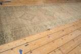 Angled view along a distressed Serab runner showing the soft, worn texture and geometric medallion pattern.
