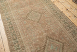 Evenly worn pile on a distressed Serab runner showing dusty blush and jade green geometric motifs.