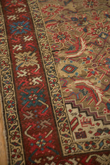 Angled close-up of the antique Karabagh's burgundy crab-style border and camel Herati field.