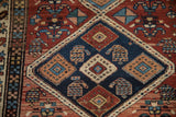 Vintage Serab rug detail: navy blue diamond with stylized boteh motifs and red field.