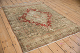 Vintage distressed Persian Bijar rug from an angle, showcasing its traditional design and worn texture.