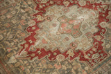 Worn pile on the cherry red and seafoam green medallion of a distressed vintage Persian rug.