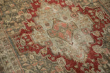 Angled view of the distressed Bijar rug's medallion, with wear showing the knot heads.