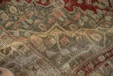 Close-up of the distressed Bijar's low-pile texture, with wear showing the white foundation threads.