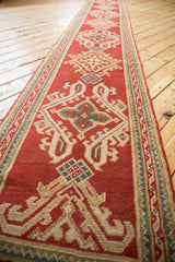 Vintage Oushak rug detail: cherry red field, hooked quatrefoil motifs, and ribboned vine border.
