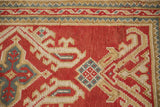 Traditional Oushak rug border, featuring cherry red, ivory, and sky blue geometric patterns.