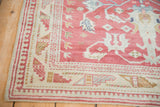 Corner detail of a vintage Anatolian rug showing an ivory border with pawn and serpent design motifs.