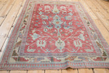Low angle view of a distressed Anatolian rug, showing the flow of red and blue palmettes.