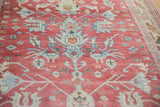 Detailed view of the distressed, low-pile weave and blue palmette motif on a vintage Turkish rug.