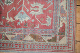 The corner of a distressed Anatolian rug, showing its geometric serpent and pawn motif borders.