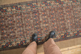 Intricate allover lattice design and wide camel hair border of an antique Persian Serab runner.