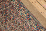 Corner detail of an antique Serab runner showing its wide camel hair border and intact side cord.