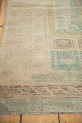 Distressed texture and geometric patterns in dusty teal and pale brown on this Belouch rug.