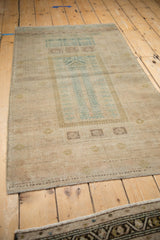 Worn geometric pile and short fringe on the end of a distressed Belouch rug.