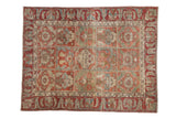 A vintage distressed Baktiari rug with a paneled field of floral motifs in dusty red, blue, and green.