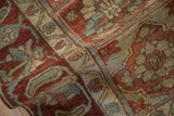 Woven texture and low pile of a distressed Baktiari rug in dusty raspberry and slate blue.