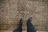 A top-down view showing the decorative wear and soft texture of a vintage Sarouk rug.
