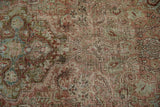 Distressed texture of a vintage Sarouk rug with soft raspberry and olive green arabesques.