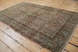 Long-view of the distressed Sarouk rug's soft floral design and time-worn patina.