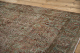 Low pile showing knot heads and arabesque patterns on a distressed vintage Sarouk rug.