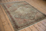 Angled perspective of a vintage Baktiari rug showing the softened tones of its panelled design.