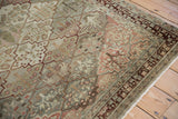 Corner detail of a distressed Baktiari rug with trellis lattice panels in slate blue and red.