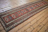 Angled view highlighting the natural contour and geometric pattern of an antique Caucasian runner.