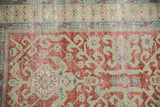 Distressed cherry red field and seafoam green geometric hook and latch motifs.
